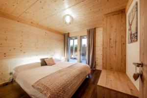 格林德尔瓦尔德Chalet CARVE - Apartments EIGER, MOENCH and JUNGFRAU的小木屋内一间卧室,配有一张床