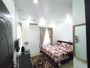 阿布贾Cosmetro Homes Abuja的一间小卧室,配有一张床和镜子