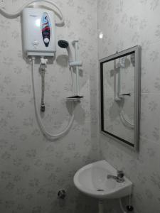 马六甲克勒邦贝斯卡镇旅馆的浴室配有水槽和墙上的吹风机