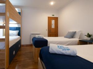 埃斯波森迪InnEsposende Sports Hostel的客房设有两张床和一张双层床。