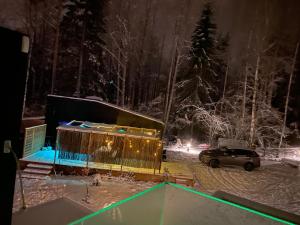 奥克什贝里亚Tiny house in the middle of nature的夜间停在雪覆盖的院子中的汽车