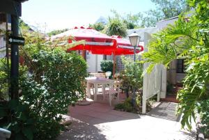 克尼斯纳克尼斯纳宾馆的一个带桌子和红色遮阳伞的庭院