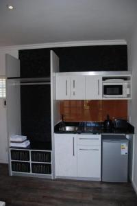 克尼斯纳克尼斯纳宾馆的厨房配有白色橱柜和微波炉