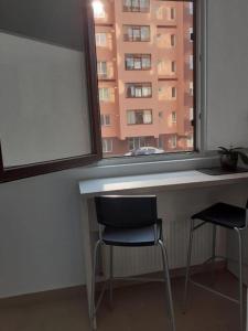 RoşuLuxury 1 Bedroom Apartment的带窗户的客房内的一张桌子和两把椅子