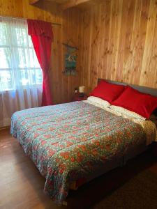 柯纳里佩Cabaña en Coñaripe Sector Termas Geométricas的卧室配有一张床铺,位于带木墙的房间内