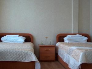 秋明Hotel Four Rooms on Energetikov的两张睡床彼此相邻,位于一个房间里