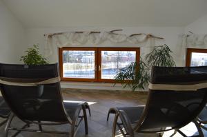 拉德施塔特Filzerlehen的带窗户的客房内配有两把椅子和一张桌子