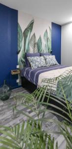 CanohèsAppartement classé 3 étoiles - Canohès的一间卧室配有一张蓝色墙壁和植物床