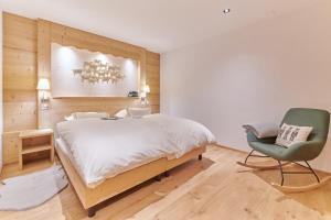 尚佩里Boutique Hotel Beau-Séjour & Spa Superior的一间卧室配有一张大床和一张绿色椅子