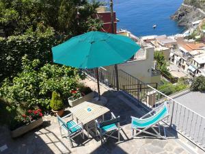 马纳罗拉ARIA DI MARE, Manarola - Camere con vista mare!的阳台配有桌椅和遮阳伞