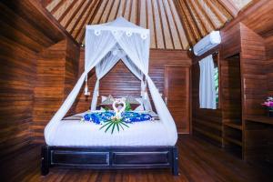 蓝梦岛Karang Mas Villa Nusa Lembongan的一间卧室配有一张带天蓬的床