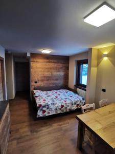 利维尼奥La Stua Livigno的一间卧室设有一张床和木墙