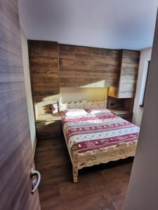 利维尼奥La Stua Livigno的一间卧室配有一张木墙床