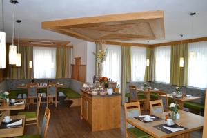 萨尔茨堡波尔瓦恩旅馆的餐厅设有木桌、椅子和窗户。