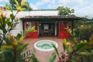 马尼萨莱斯Termales El Otoño的一间设有红色门和庭院的小房子
