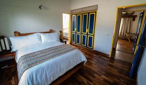马尼萨莱斯Termales El Otoño的一间卧室配有一张床,铺有木地板