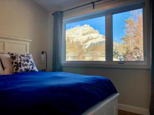 班夫山景住宿加早餐旅馆的一间卧室设有蓝色的床和大窗户