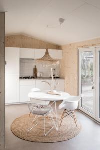 宁斯佩特NOYR. tiny house的白色的厨房配有白色的桌子和椅子