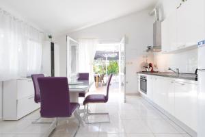 尼亚卢卡Villa Goga的白色的厨房配有紫色椅子和桌子