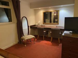 利灰狗酒店的客房设有带椅子和镜子的书桌。