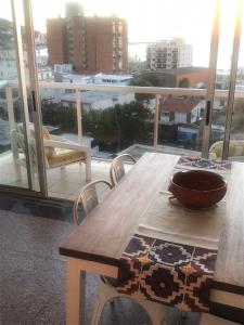 皮里亚波利斯Piriapolis apartamento的阳台上的木桌和碗