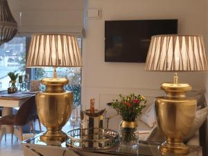 米兹多洛杰Apartament Prestige & Sea Balticus A4的两盏金灯,坐在玻璃桌旁,设有用餐室