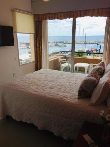 皮里亚波利斯圣雷莫特拉萨斯酒店的一间卧室设有一张大床和一个大窗户