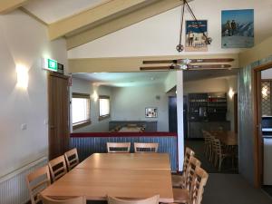 福尔斯克里克Cooroona Alpine Lodge的一间带木桌和椅子的用餐室