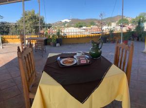 瓦哈卡市Posada Regional的一张桌子,上面有一盘食物和花瓶