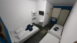 阿拉夏奇巴海滩Pousada da Ponte的一间白色的小房间,里面设有两张床