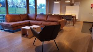 拉罗什-阿登Ardennature vakantiehuizen met privé-sauna的客厅配有棕色沙发和桌子