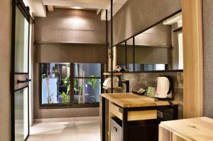 高雄歐閣精品汽車旅館-簡愛館的厨房配有书桌和窗户。