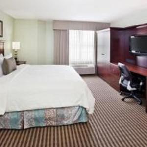 亚特兰大亚特兰大巴克黑德智选假日套房酒店的酒店客房设有一张大床和一张书桌。