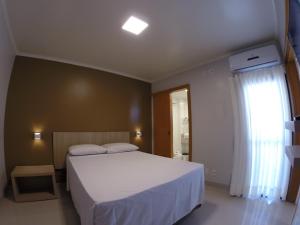 戈亚尼亚Flat Apart Hotel Crystal Place的卧室设有一张白色大床和一扇窗户。