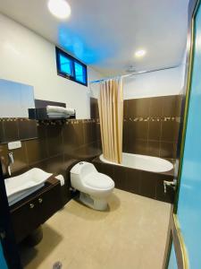 里奥班巴Hotel Montecarlo的浴室配有卫生间、盥洗盆和浴缸。