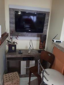 乌鲁瓜亚纳Centro Studio的客厅配有电视和带椅子的桌子