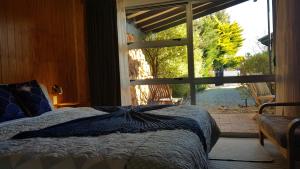 瓦纳卡巅峰运动木屋酒店的一间卧室设有一张床和一个大窗户