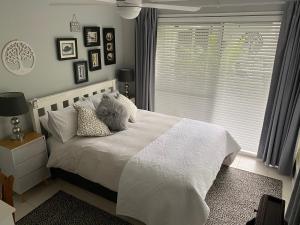 布里斯班纸张住宿加早餐旅馆的卧室配有带枕头的白色床和窗户。