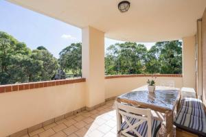 悉尼Home away from Home Parramatta的客房设有桌椅和大窗户。