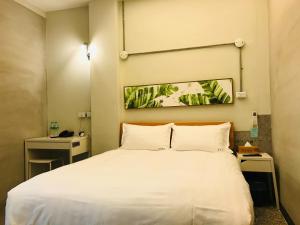 嘉义市嘉宫旅社的卧室配有一张带两个枕头的大白色床