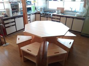 真庭市富乃亭的厨房配有木桌和椅子