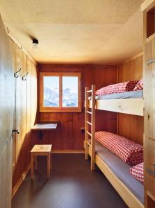 克洛斯特斯Erezsässhütte的客房设有两张双层床和一扇窗户。
