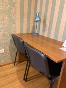 彼尔姆科兹亚玉斯卡酒店的一张桌子,上面有两把椅子和一盏灯