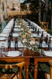 基乌斯迪诺圣嘉嘉诺农家乐的长桌,带葡萄酒瓶和鲜花
