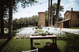 基乌斯迪诺圣嘉嘉诺农家乐的户外婚礼,配有白色的椅子和鲜花桌