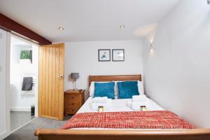 凯格沃思The Little Apartment的一间卧室配有一张带蓝色枕头的大床