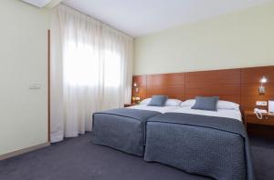 马德里Porcel Torre Garden的一间卧室设有两张床和大窗户