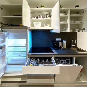 纽伦堡Nurban Apartments Oldtown的厨房配有白色橱柜和开放式冰箱。