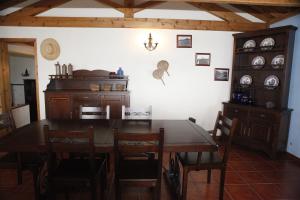 CapeloCasa capelinhos的一间带木桌和椅子的用餐室