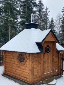 大卡尔洛维采U Justina na břehu的小木屋,屋顶覆盖着雪